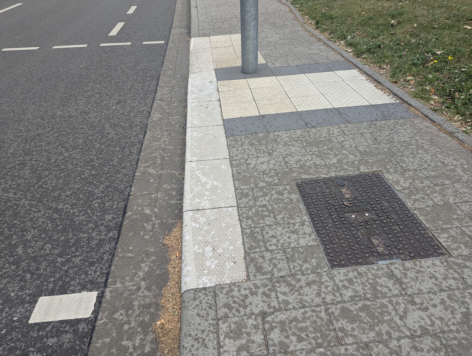 Partially flush kerb at a pedestrian crossing, combined with tactile paving and a 3cm upstand